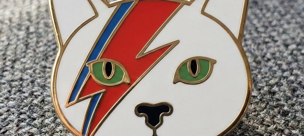 Bowie style cat hard enamel pin A stylish rock-inspired cat lapel pin perfect for music fans and enamel pin collectors.badge with bold geometric face design